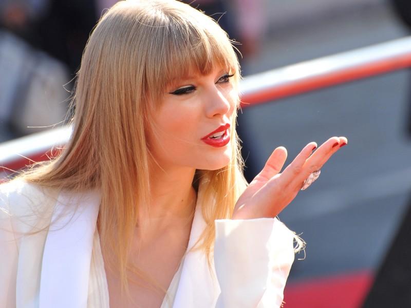 Taylor Swift blowing a flying kiss.