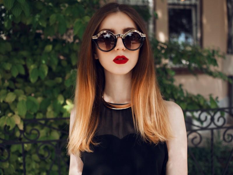 Stylish woman wearing sunglasses and showing off her ombre hair color.