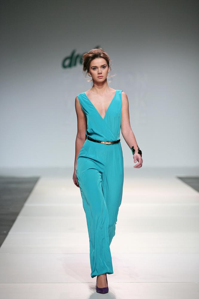Model wearing overalls on the runway.