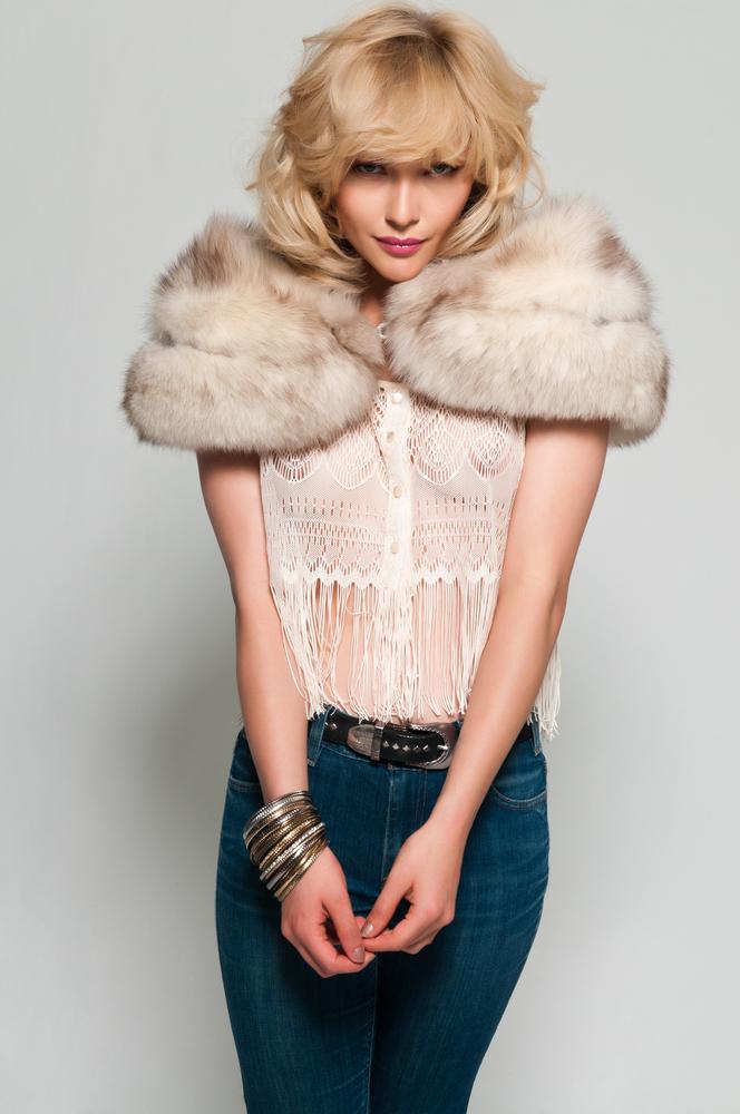 Woman wearing a fur stole and a fringe top.
