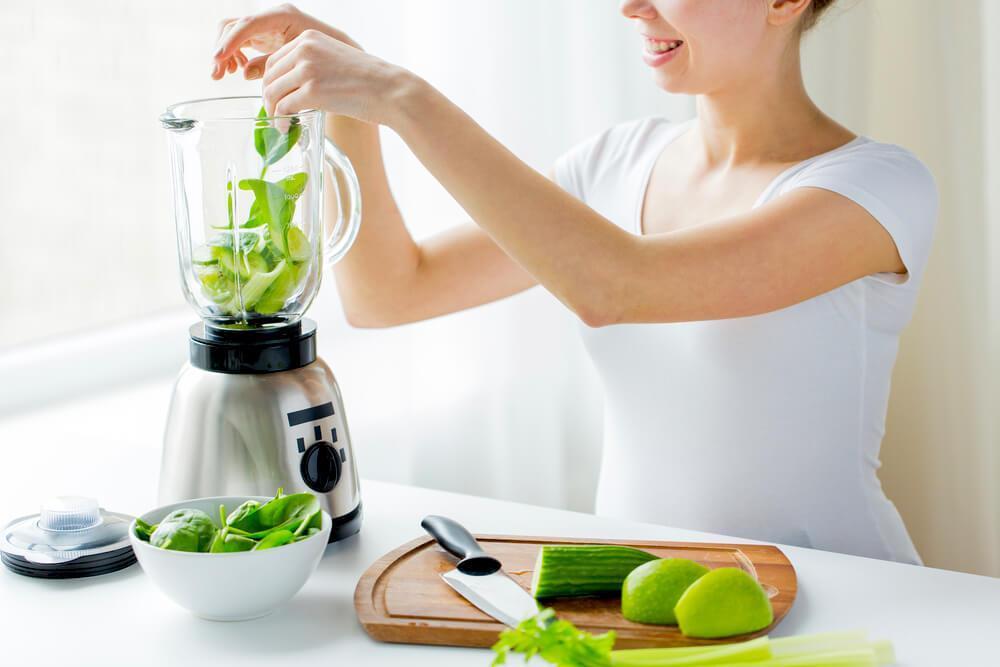 woman prepping green smoothie