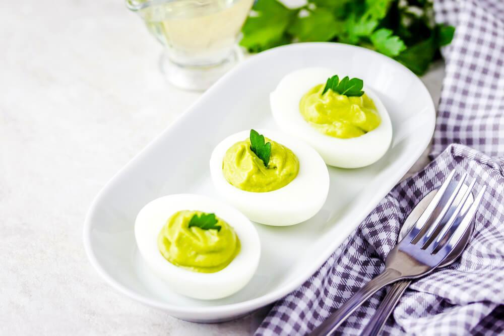 Three halved avocado devilled eggs