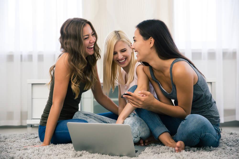 Girls laughing at laptop