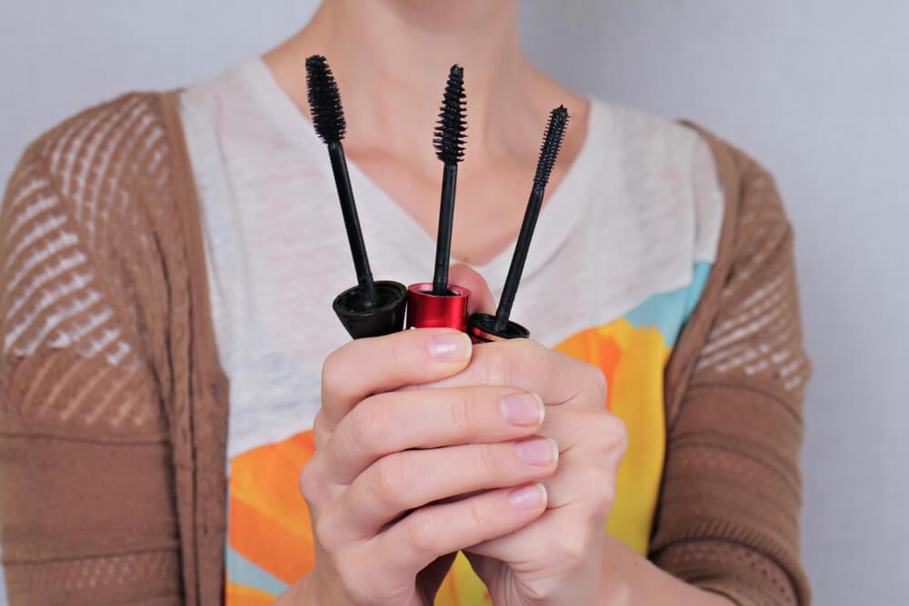 Woman holding mascara brushes