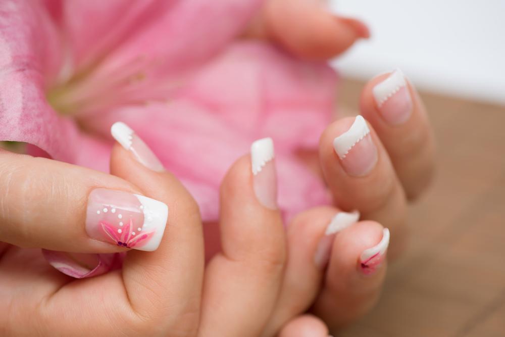 Woman with a french manicure and subdued pastel colors. 