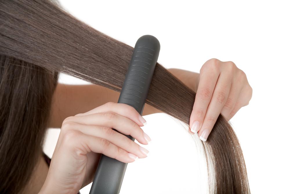 Woman straightening her hair.
