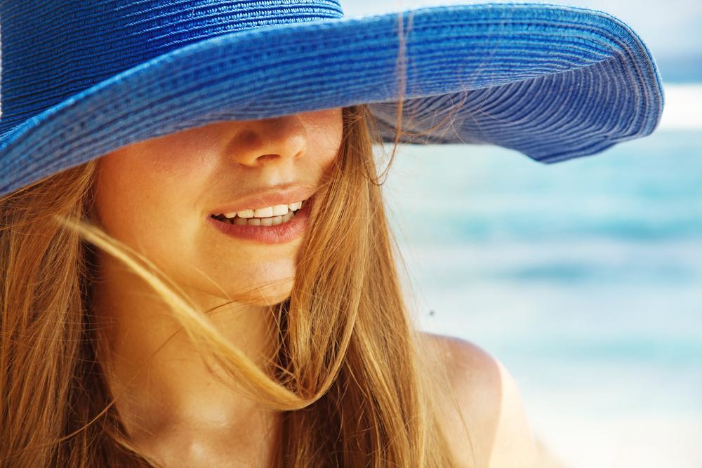 Woman wearing a hat in a beach.