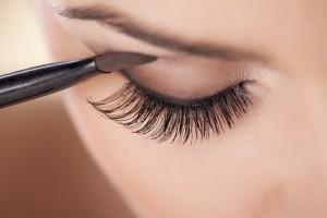 Woman applies smokey eye in brown shades