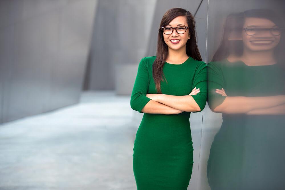Professional young woman in green tailored dress