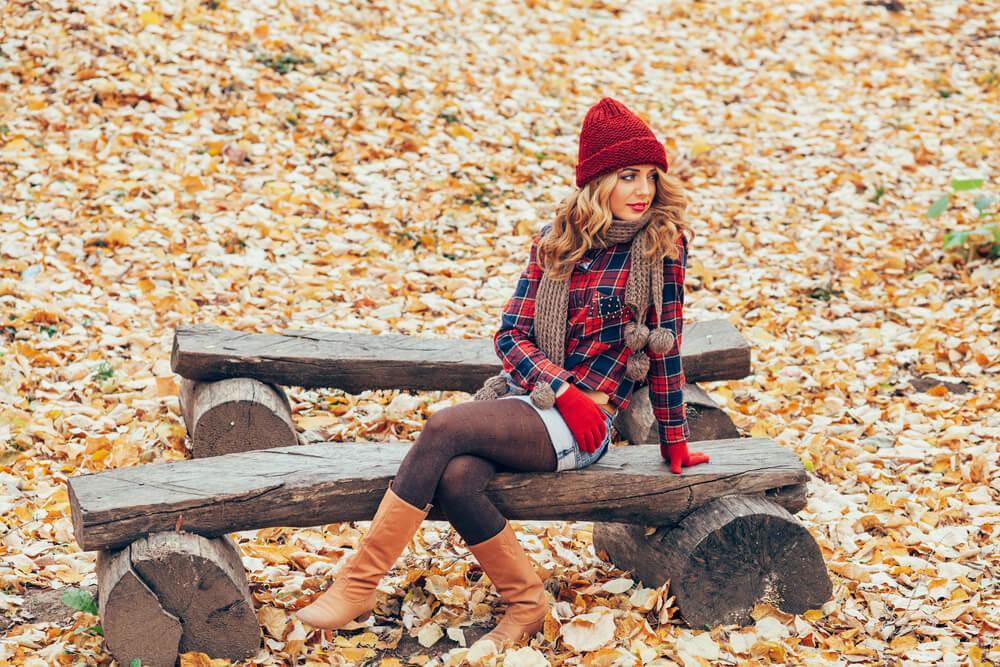 Woman on bench wearing shorts with tights and boots