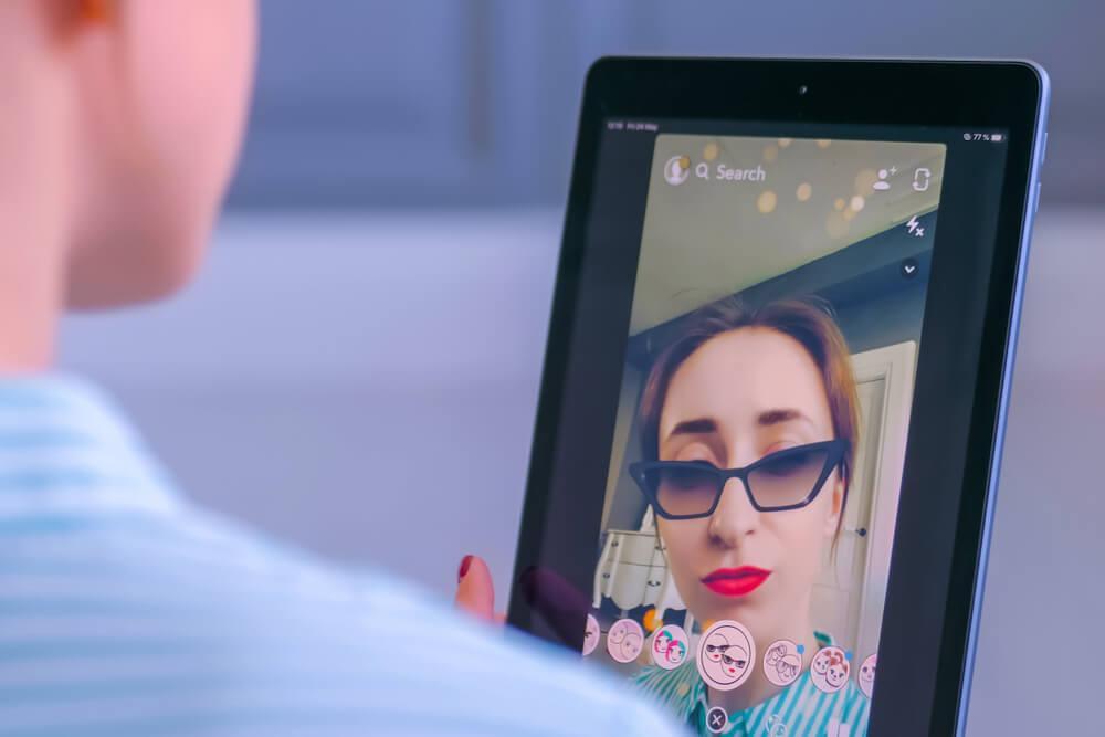 Woman taking selfie on Snapchat with filter