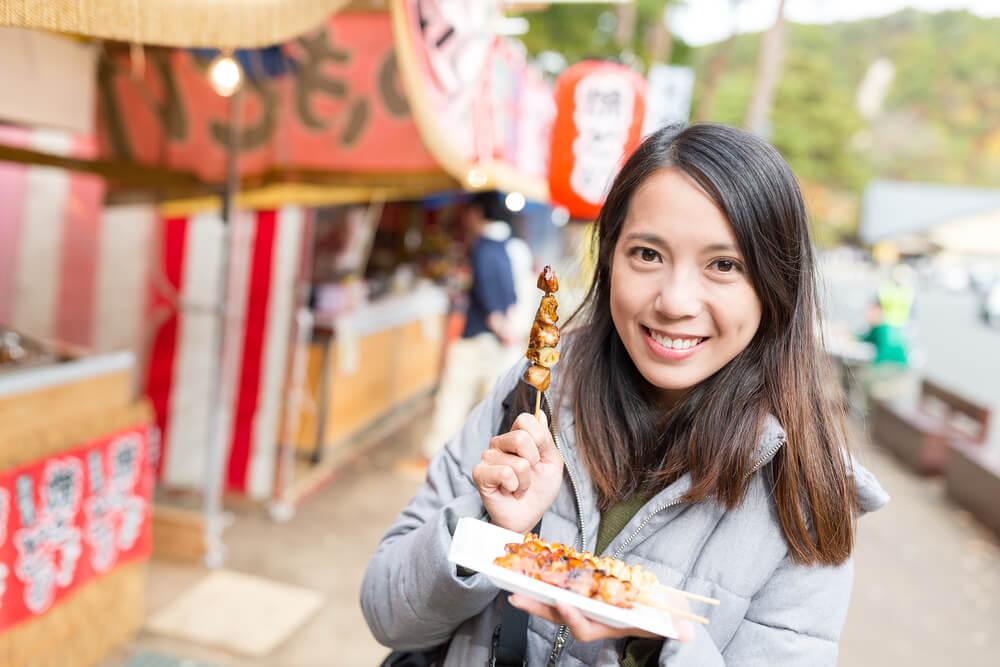 Woman eating street snack in Japan
