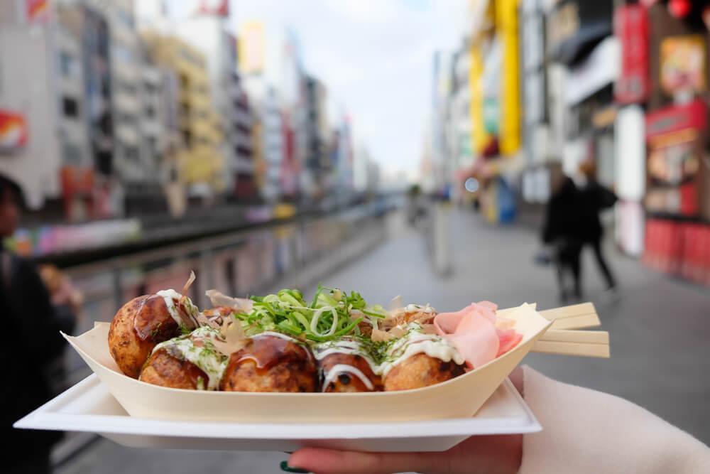 Holding tray of street food in Osaka