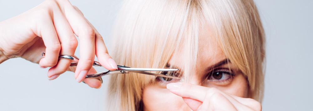 Woman cutting her own bangs