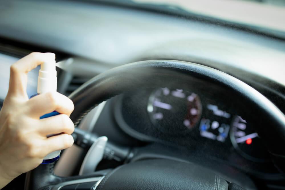 Hand spraying car steering wheel